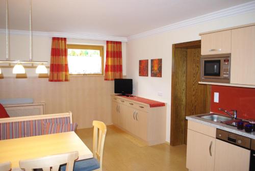 a kitchen with a table and a dining room at Haus Thurner in Wagrain