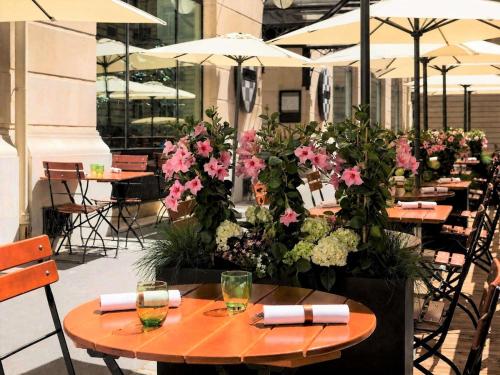a restaurant with tables with flowers and umbrellas at Sofitel Paris Arc De Triomphe in Paris