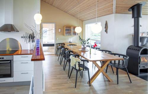 a kitchen and dining room with a wooden table and chairs at Holiday Home Kuskevej Jerup X in Jerup