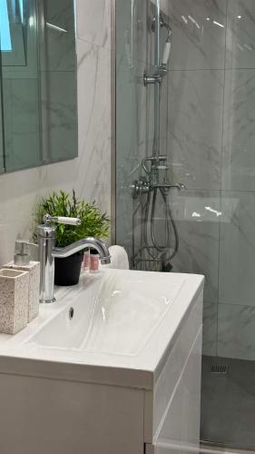 a bathroom with a white sink and a shower at Mama’s house in Ágios Rókkos