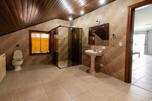 a bathroom with a toilet and a shower and a sink at Casa de praia Peruibe in Peruíbe