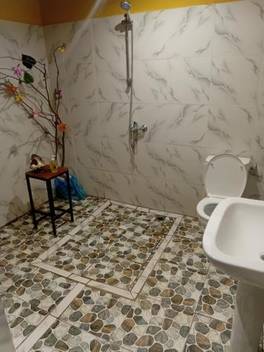 a bathroom with a shower and a tiled floor at Tereva home 1 in Bora Bora