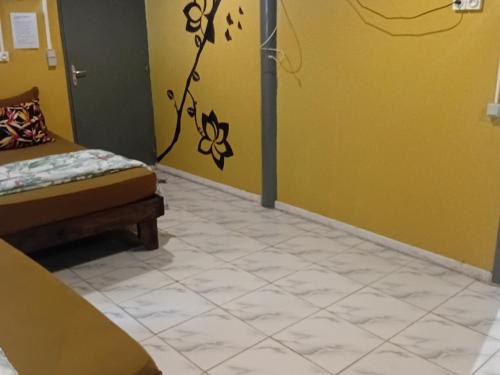 a room with a bed and a yellow wall at Tereva home 1 in Bora Bora