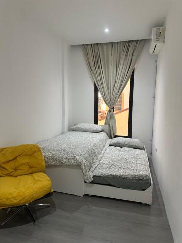 a bedroom with two beds and a window at The Perch House in Silañgang Mayao