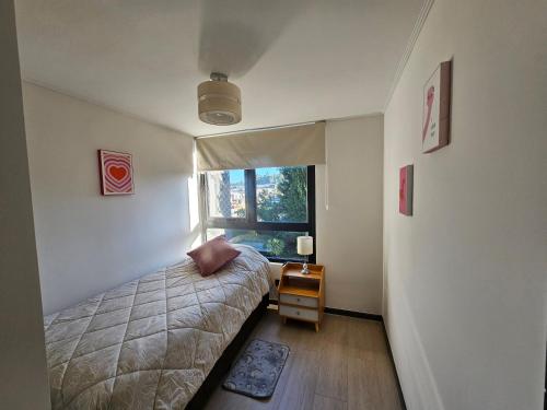 a small bedroom with a bed and a window at Depto con Piscina Temperada 2D y 2B in Puerto Varas