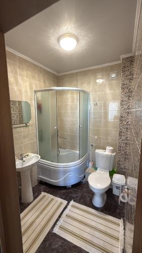 a bathroom with a tub and a toilet and a sink at Берег in Bosteri