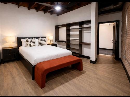 a bedroom with a bed and a bench in it at Brick & Bed Riverfront Lofts, T 308 in Saint Louis