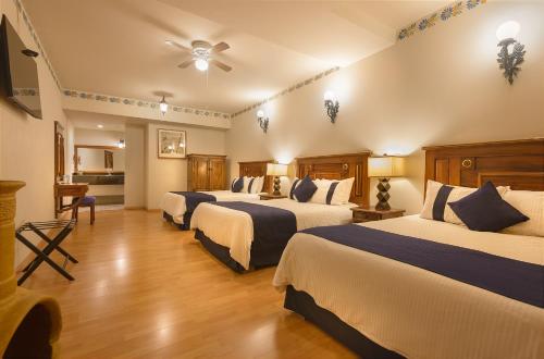 a hotel room with three beds in a room at Hotel Boutique Grand Mayes in Pátzcuaro