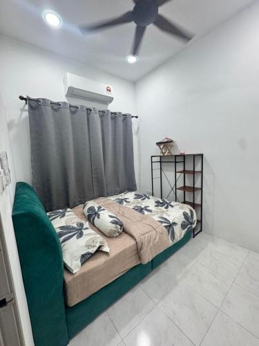 a bedroom with a bed and a ceiling fan at Dgajah Homestay in Batu Gajah