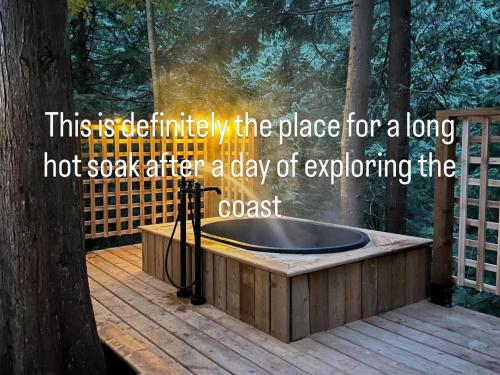 a hot soak tub on a deck in a forest at Creekside Bunkies in Roberts Creek