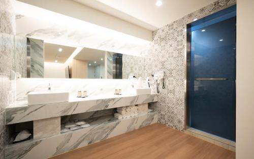 a bathroom with two sinks and a large mirror at Browndot Hotel Mokpo Gotbawi in Mokpo