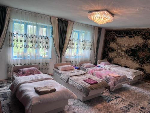 a bedroom with two beds and a chandelier at Satina Jenish in Syn-Tash