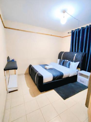 a bedroom with a bed with blue curtains at 1 Bedroom in Section 58 behind Kunste Hotel in Nakuru