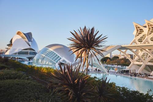 a group of buildings with a palm tree in the foreground at Apartamentos Nuevos en Valencia in Valencia
