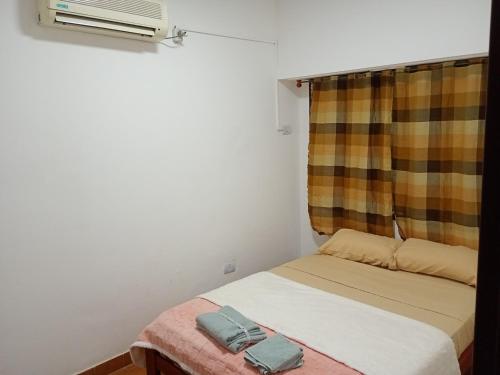 a small bedroom with a bed and a window at Lindo recuerdos in Posadas