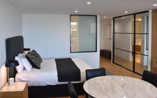 a bedroom with a bed and a table and chairs at Kove Apartment - G03 in Kiama