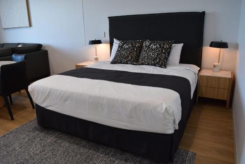 a bedroom with a large bed with a black headboard at Kove Apartment - G03 in Kiama