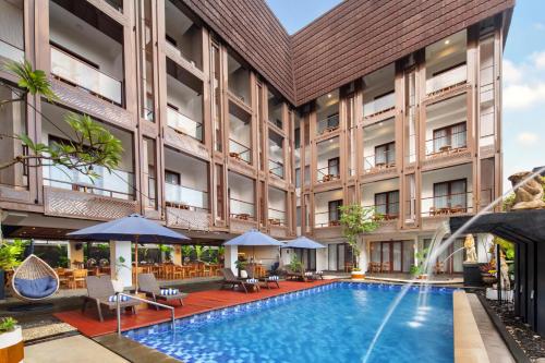 an exterior view of a hotel with a swimming pool at Nadi Hotel Legian in Legian