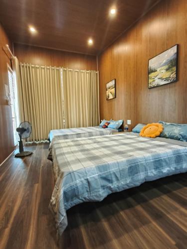 a large bedroom with two beds and a fan at H Vy Homestay in Phương Phi