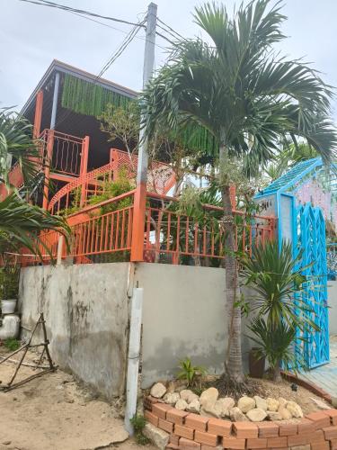 a house with a palm tree in front of it at H Vy Homestay in Phương Phi