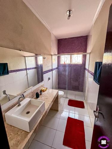 a large bathroom with a sink and a shower at Pousada Casa Shanti in Dourados