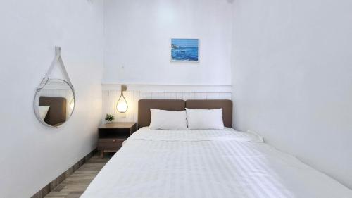 a bedroom with a large white bed with a mirror at Khách Sạn Lý Sơn Phú Sỹ in Ly Son
