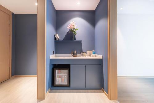 a living room with blue walls and a fireplace at 东莞凤岗南天大厦亚朵酒店 in Qinglinjing