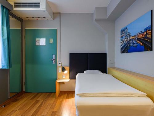 a bedroom with a bed and a painting on the wall at ibis Köln Frechen in Cologne