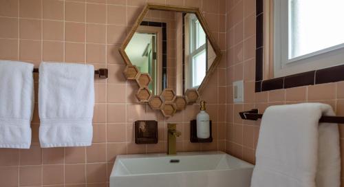 a bathroom with a sink and a mirror and towels at Gale River House - Boutique Hotel in Franconia
