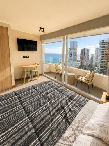 a bedroom with a large bed and a view of the ocean at Estudio peninsula Cavancha in Iquique