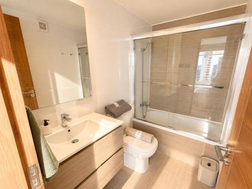 a white bathroom with a toilet and a sink at Estudio peninsula Cavancha in Iquique
