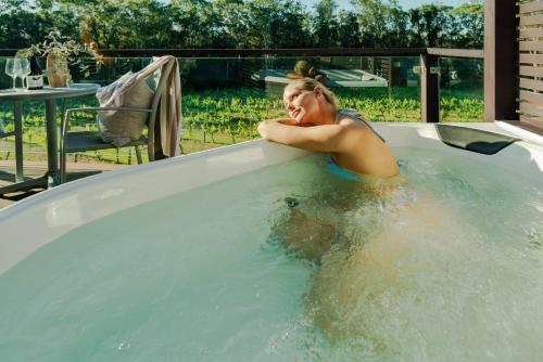 a woman is sitting in a hot tub at Hermitage Lodge in Pokolbin