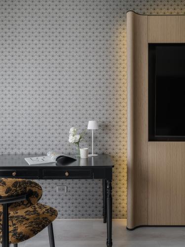 a desk with a chair and a television on a wall at T Hotel in Taichung