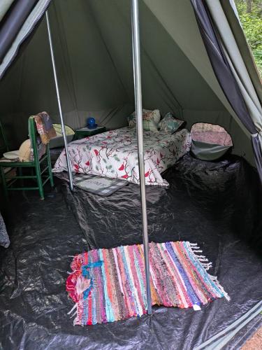 a tent with a bed and blankets in it at Goldenrod Gap in Wellington
