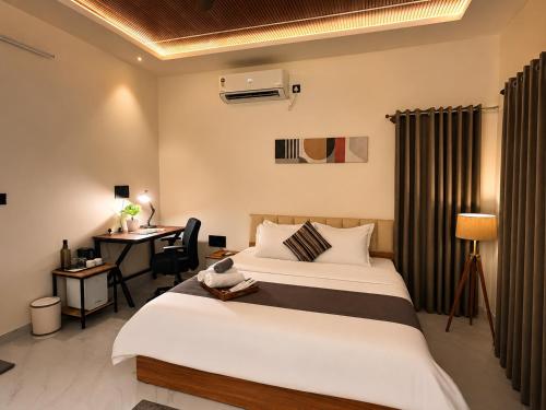 a hotel room with two beds and a desk at Kalarava private rooms in Chikmagalūr