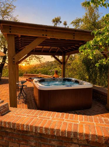 a hot tub under a wooden pergola at Spacious Villa Private Gameroom in Fallbrook