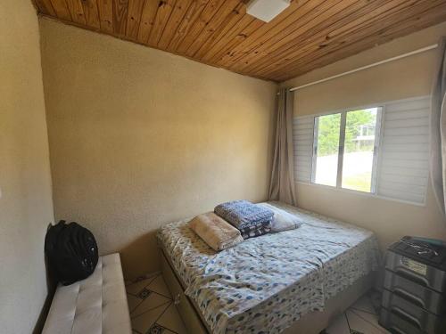 a bedroom with a bed in a room with a window at Rancho da Benção in São Roque