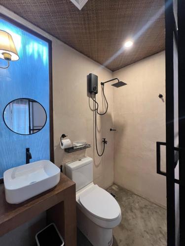 a bathroom with a toilet and a sink and a shower at Kundiman Siargao, General Luna in General Luna