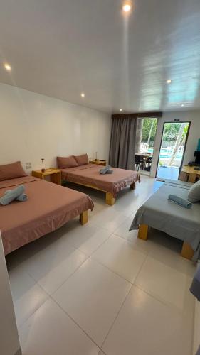 a room with two beds and a living room with a couch at Pili Beach Resort Agmanic in Santa Fe