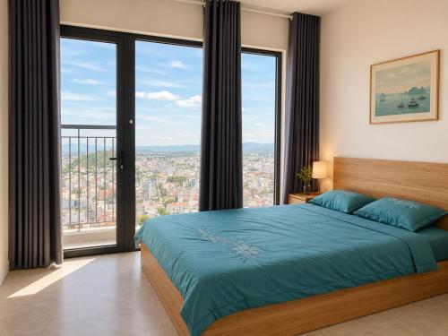 a bedroom with a large bed and large windows at Jess Apt in Tuy Hoa