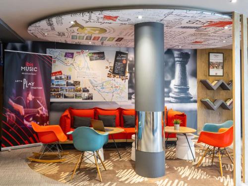 a restaurant with orange chairs and tables in a room at Ibis Bilbao Barakaldo in Barakaldo