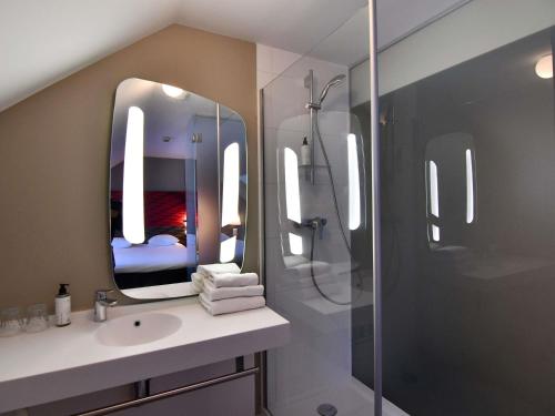 a bathroom with a shower and a sink and a mirror at ibis Brest Kergaradec in Brest