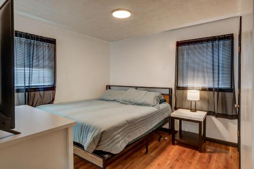 a small bedroom with a bed and two windows at Centralized Modern Home in Johnson City in Johnson City