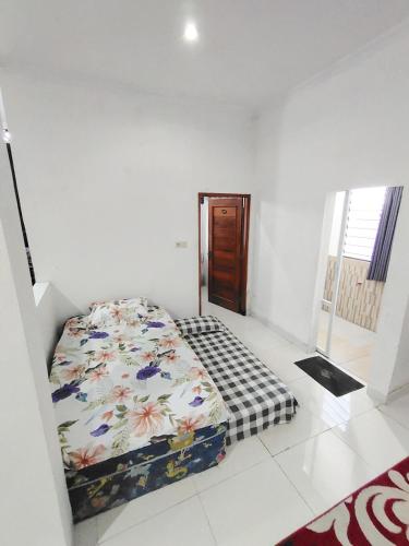 a bedroom with a bed in a white room at UnitA 5BR Kangen Homestay Jambon Yogyakarta in Cebongan