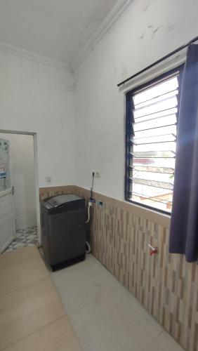 an empty room with a window and a trash can at UnitA 5BR Kangen Homestay Jambon Yogyakarta in Cebongan