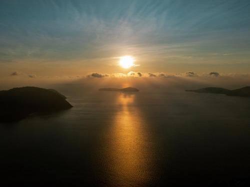 a sun setting over a large body of water at Kiri Anda Villa Phuket in Rawai Beach