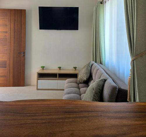 a living room with a couch and a flat screen tv at Neramit House in Ko Phangan