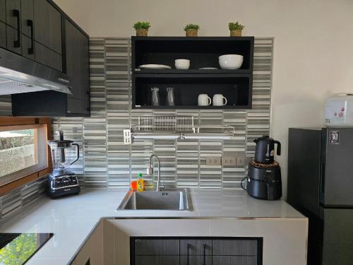 a kitchen with a sink and a refrigerator at Neramit House in Ko Phangan