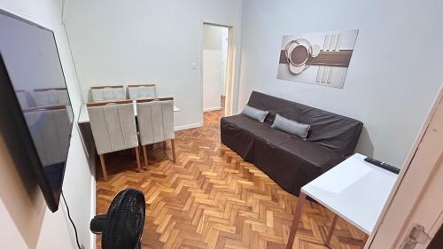 a living room with a couch and a television at Studio Copacabana Exclusivo, Na Rua Silva Castro, 4 min da Praia e Metrô, Ganhe 1 ESPUMANTE de boas vindas nas reservas acima de 3 dias, para brindar essa experiência icônica, com Ar e Wi-Fi in Rio de Janeiro