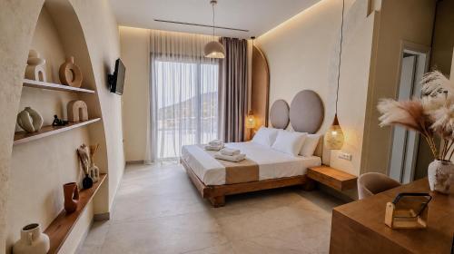 a bedroom with a bed and a large window at Anemolia Villas in Karpathos